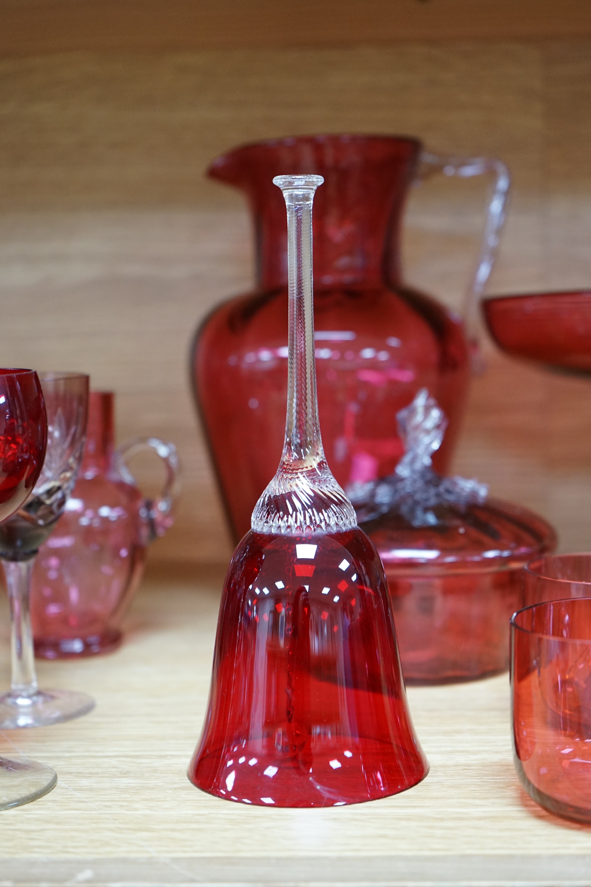 Mixed cranberry glassware to include jugs, glasses, jars and a comport, largest 23cm high. Condition - fair to good